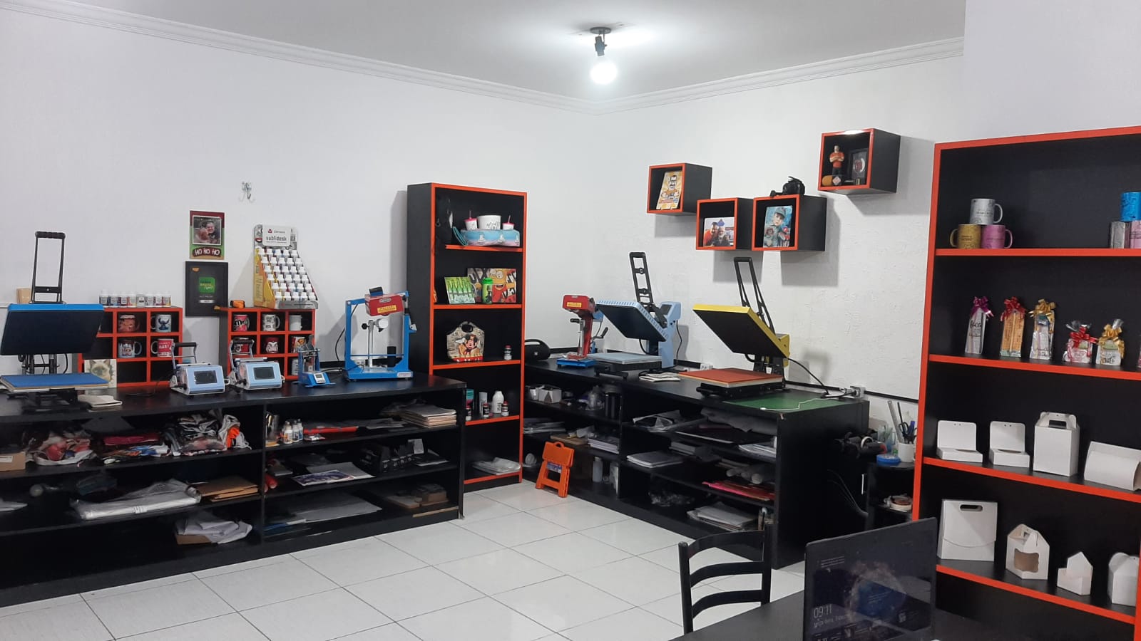 Visão ampla da sala de treinamento com prensas e equipamentos de sublimação